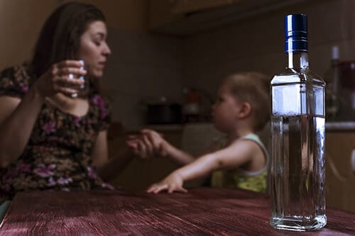 Mother with drink in hand and child nearby may need to know how substance abuse affects the family