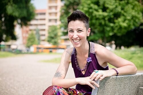 Smiling woman on park bench happy about lgbtq support groups at Beaches Recovery