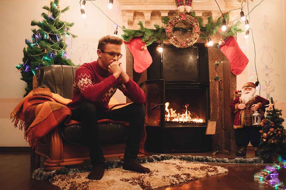 adult male sitting down in a chair upset near holiday decor