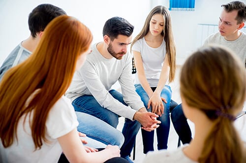 people participate in group therapy as part of LGBTQ rehab programs