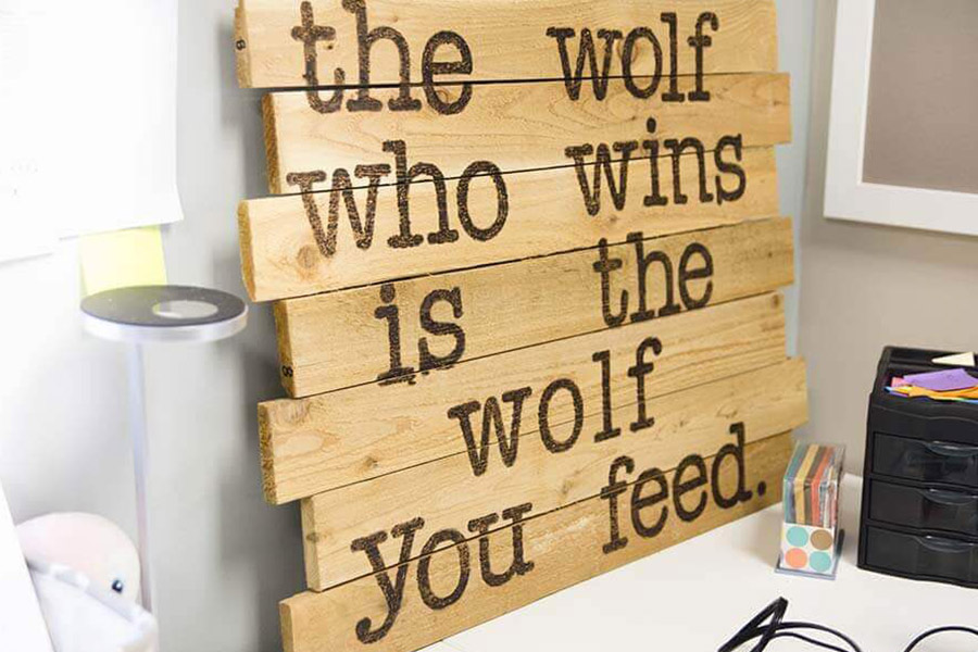 Wooden sign that says 'The Wolf Who Wins Is The Wolf You Feed'