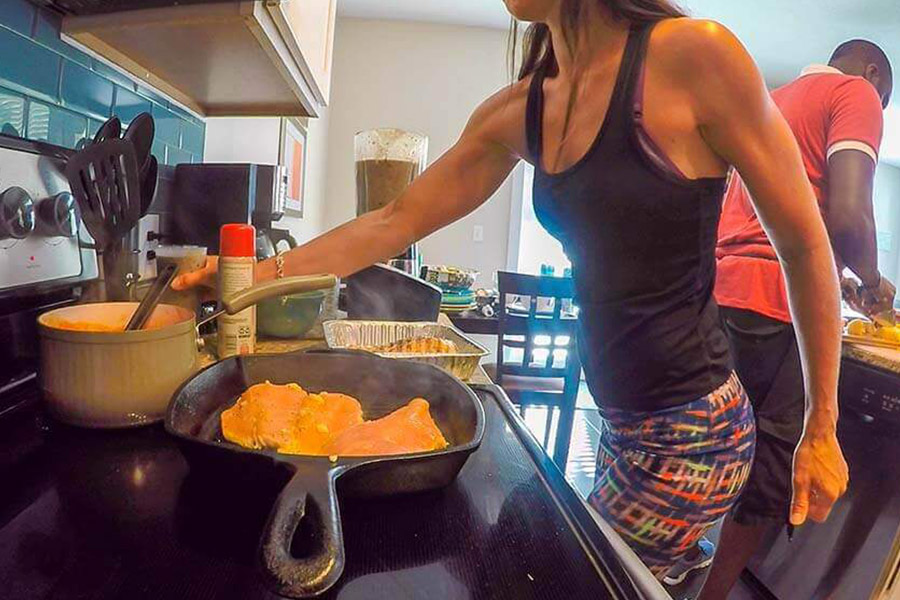 Female patient in a drug rehab home cooking a meal on the stove
