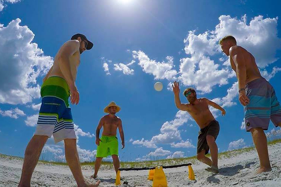 Four men on the beach playing handball