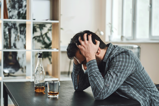 Man experiencing the signs of a drinking problem