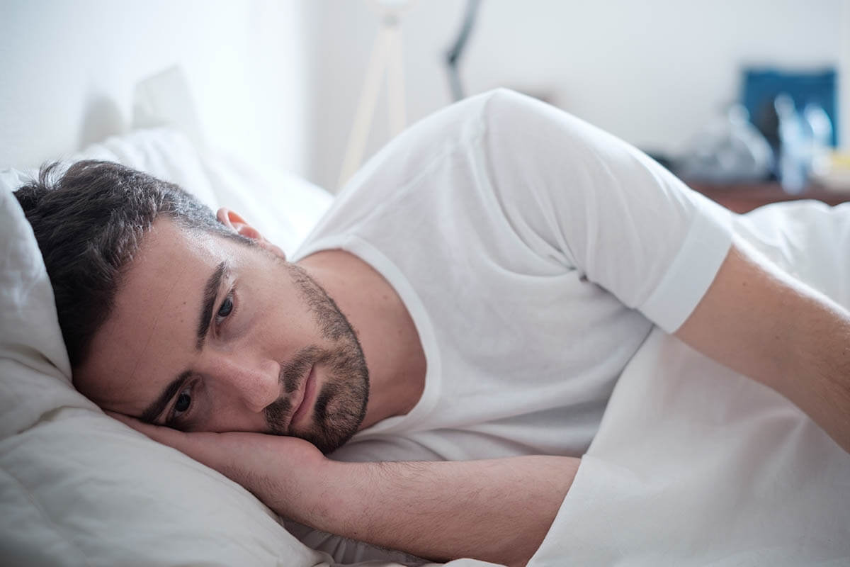 Man laying in bed wonders what is clinical depression