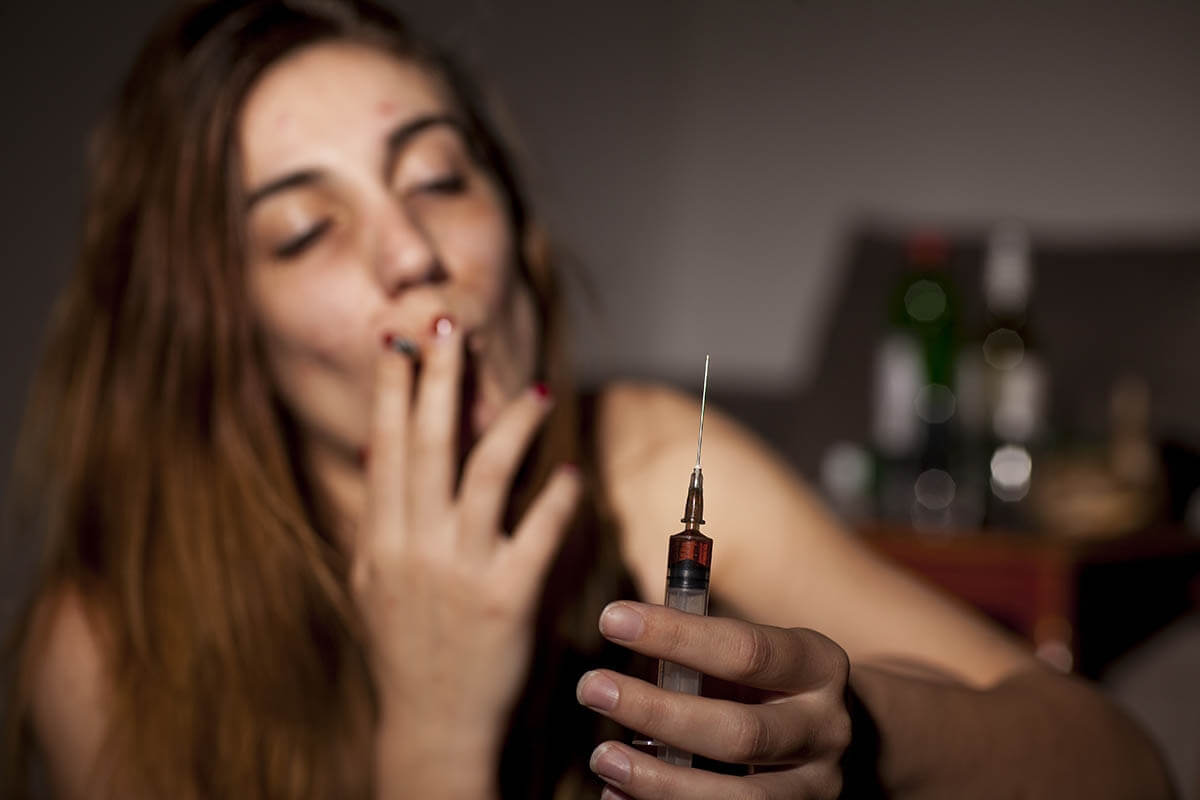 Woman holding a syringe and smoking wonders what is Special K