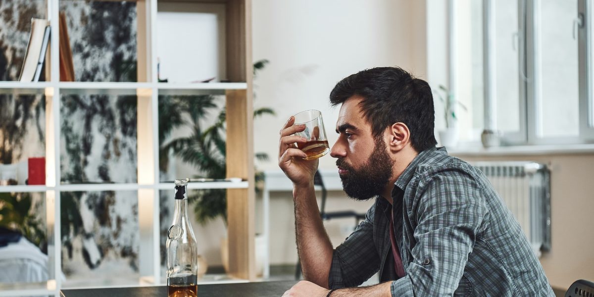 Man sits and wonders how to define alcoholism