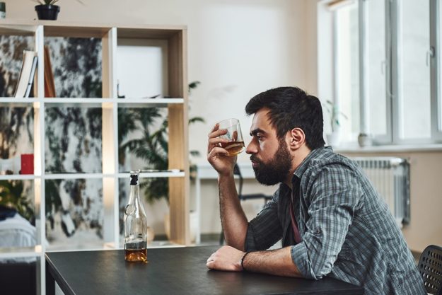 Man sits and wonders how to define alcoholism