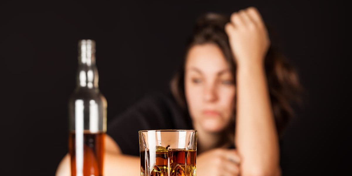 frustrated alcoholic with bottle of alcohol experiencing effects of alcohol on the brain