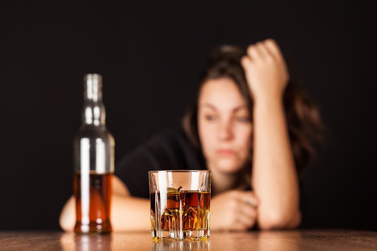 frustrated alcoholic with bottle of alcohol experiencing effects of alcohol on the brain