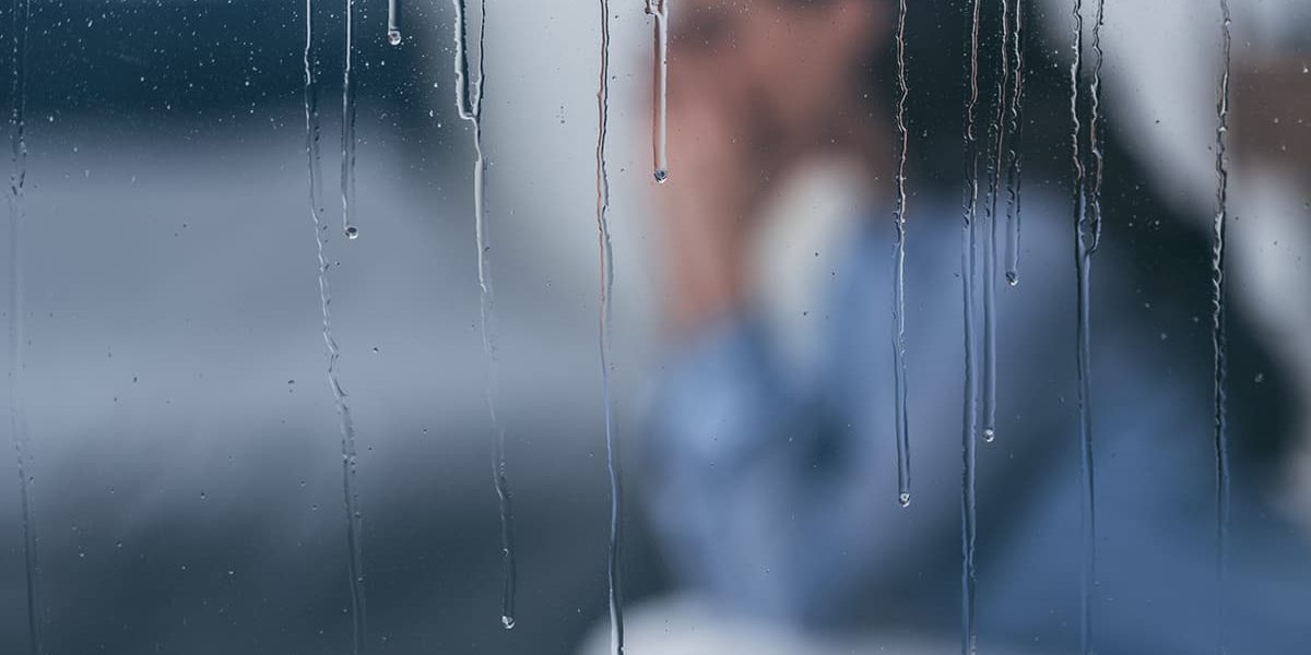 a woman sitting in the rain needing help with how to control anxiety