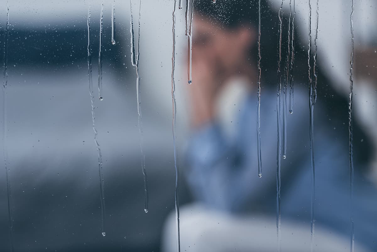 a woman sitting in the rain needing help with how to control anxiety