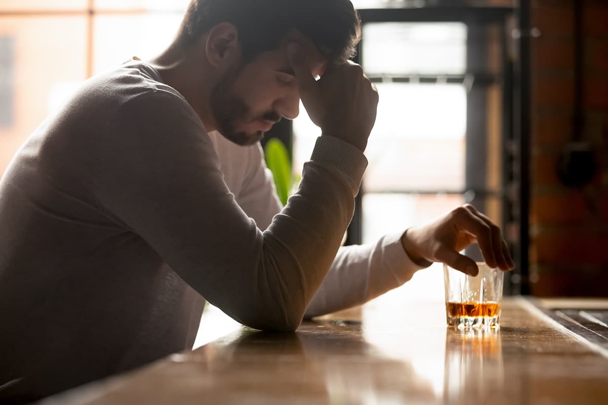man with alcohol wondering what the signs of alcohol poisoning are