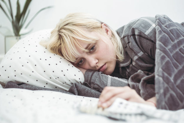 a woman in bed wondering can you mix depressants and opioids