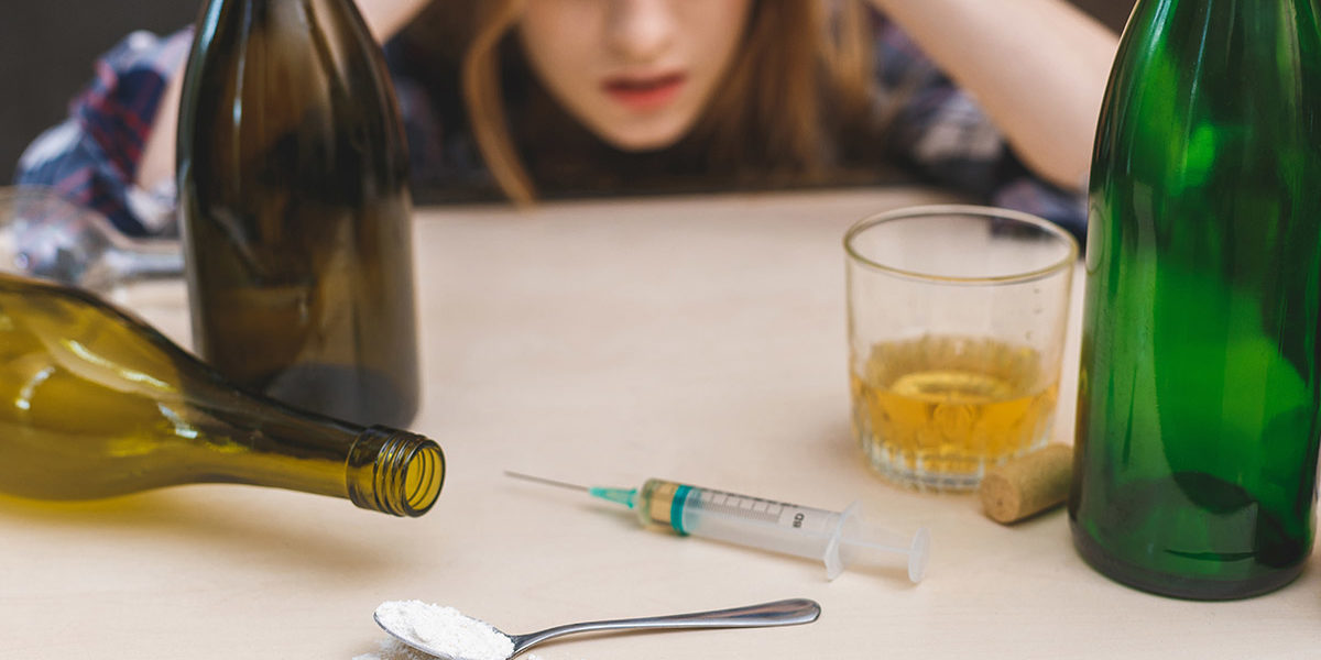 a woman mixing heroin and alcohol in distress