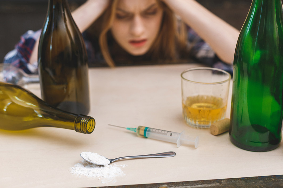 a woman mixing heroin and alcohol in distress