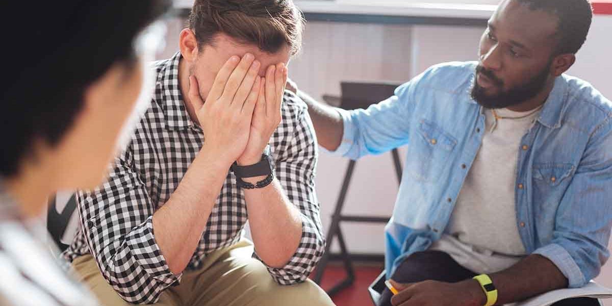 two men comforting each other in rehab