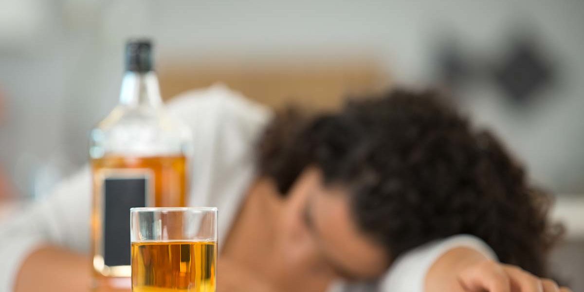 woman passed out next to whiskey showing the need for the alcohol rehab program in florida