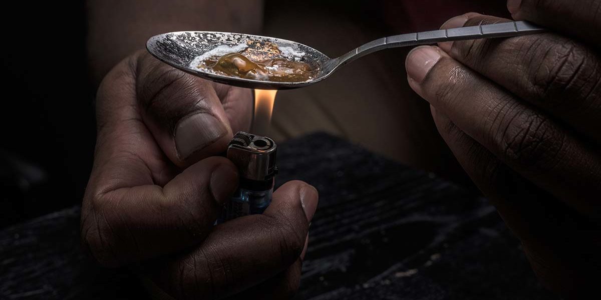 a person heating up heroin in a spoon who needs heroin rehab in Florida