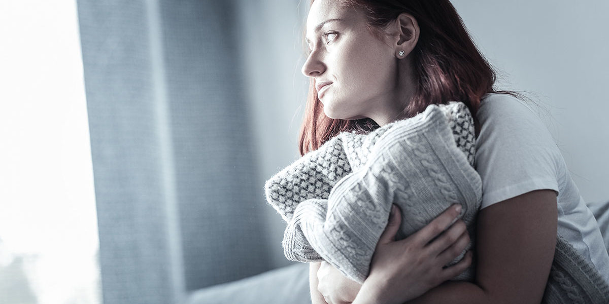 woman clutching pillow worried about addiction and your physical health