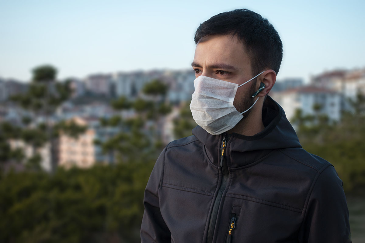man outside wearing mask knowing difference between epidemic vs pandemic