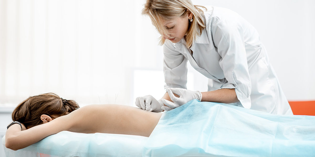 woman receiving acupuncture therapy