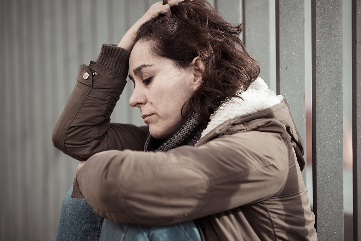 woman sitting on the ground worried about her Addiction and Sexual Health