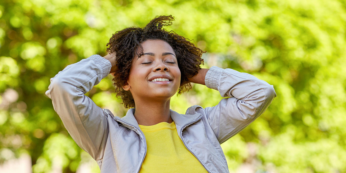 woman adjusting her hair during Mindfulness Based Relapse Prevention in the park
