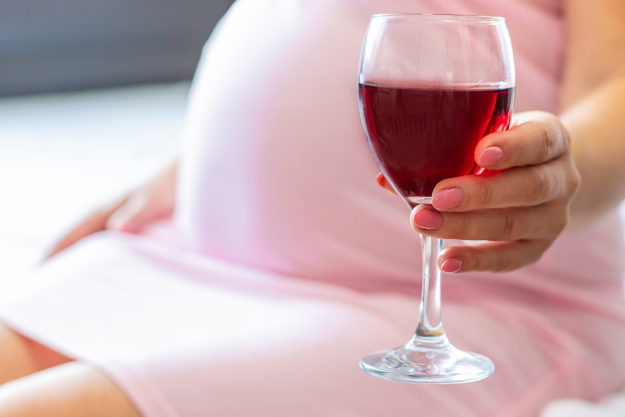 woman holding glass of wine dealing with abuse of alcohol and pregnancy