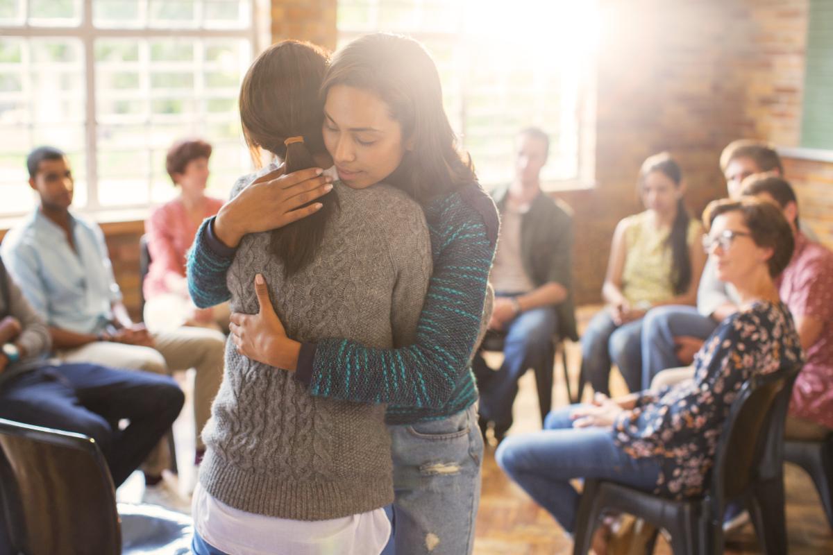 two women hugging to stop being lonely in addiction recovery