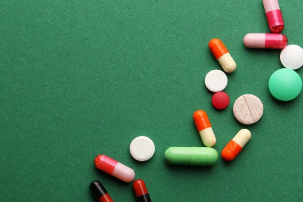 an array of prescribed drugs on green background