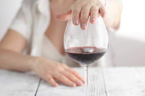 woman covering wine glass in alcohol rehab
