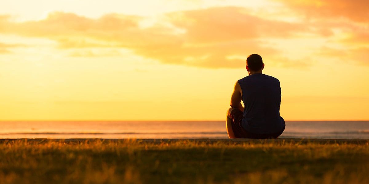 Man watching a sunset and thinking about the heroin addiction recovery rate