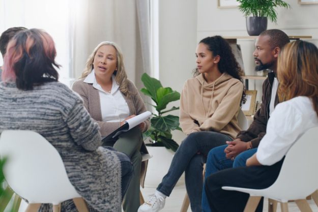 A group of people discussing group therapy topics